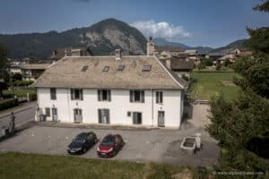 Appartement Marcelly à la vente en exclusivité chez Alpimmorama, l'agence digitale de la vallée du Giffre à Samoëns - Vue aérienne de la maison de ville où se trouve l'appartement avec le centre de Taninges